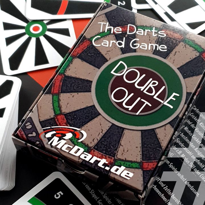 DoubleOut Das Bild zeigt ein Kartenspiel mit dem Namen "Double Out – The Darts Card Game". Die Spielschachtel liegt auf verschiedenen Spielkarten, die an eine Dartscheibe erinnern.