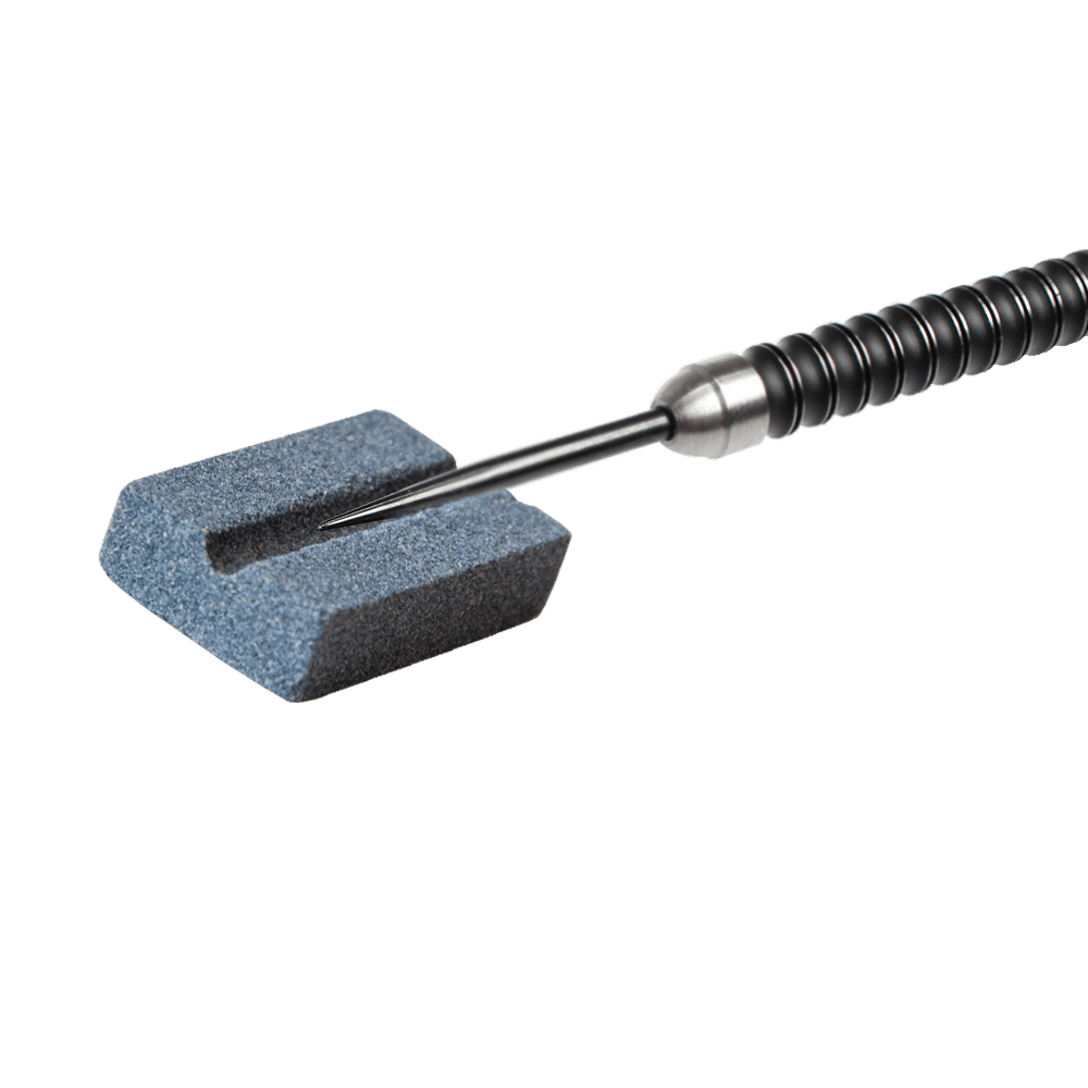 616_QD8200690_XQMax_Steeldart_Schleifstein_2 Das Bild zeigt einen XQMax Steeldart Schleifstein mit einem Dartpfeil darauf. Der Schleifstein wird verwendet, um die Spitze des Dartpfeils zu schärfen.