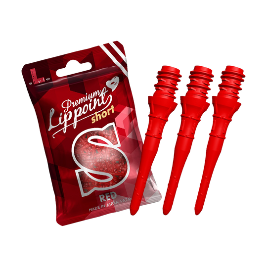 Auf dem Bild ist eine Packung mit Premium Lippoints in der Ausführung "short" zu sehen. Daneben liegen drei rote Dartspitzen.