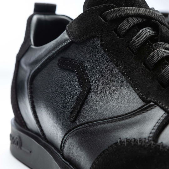 20100006-00_Triple20_Dartschuhe_Leder_Schwarz_5 Der Schuh „Triple20 Dartschuhe Leder - Schwarz“ ist aus schwarzem Leder gefertigt und hat schwarze Schnürsenkel. Die Nahaufnahme zeigt die hochwertige Verarbeitung und das dezente Design.