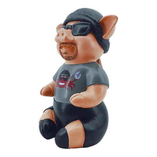 Markus Krebs Phrase Pig Das Bild zeigt eine Schweinfigur namens "Markus Krebs Phrasenschwein". Sie trägt eine Sonnenbrille, eine Mütze und ein T-Shirt mit Aufdruck.