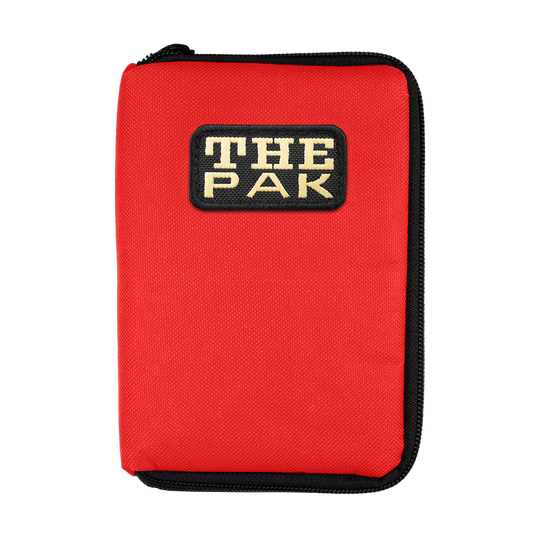 712TP_The_Pak_Dartcase_Rot_1 Das Bild zeigt ein rotes Etui mit schwarzem Reißverschluss. Auf der Vorderseite befindet sich ein Aufnäher mit der Aufschrift "THE PAK".