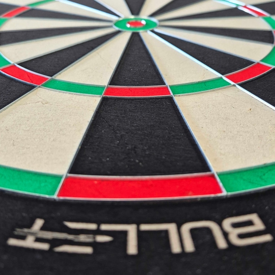 Bullet Apex steel dartboard Hier sieht man das Bullet Apex Steeldartboard. Das Produkt wird von der Seite präsentiert.