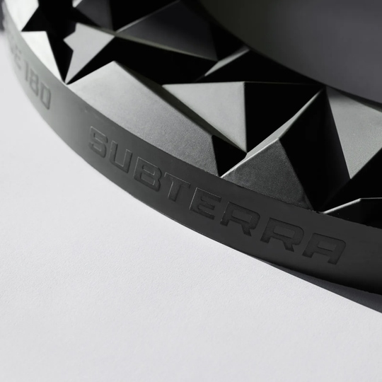 Das Precise 180 3D Dartboard Surround Subterra - Graphite ist auf dem Foto zu sehen. Diese Umrandung eignet sich ideal für Dartliebhaber.