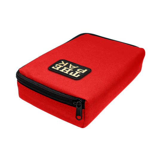 712TP_The_Pak_Dartcase_Rot_2 Das Bild zeigt ein rotes Etui mit schwarzem Reißverschluss. Auf der Oberseite steht das Logo "The Pak".
