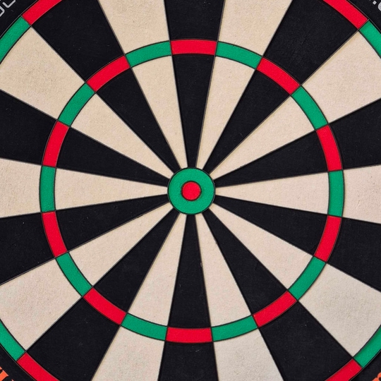 Unicorn Eclipse Ultra 2.0 steel dartboard Das Bild zeigt eine Nahaufnahme einer Dartscheibe mit klaren Farbfeldern in Schwarz, Weiß, Rot und Grün. Es handelt sich um das Produkt "Unicorn Eclipse Ultra 2.0 Steeldartboard".