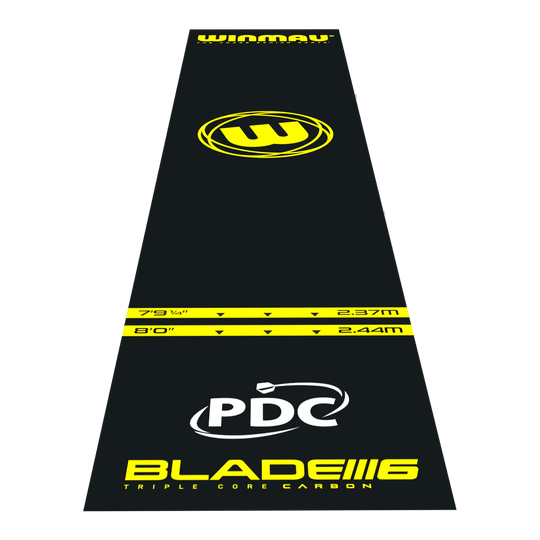 Winmau Pro-Zone Essential PVC dart mat Das Bild zeigt die Winmau Pro-Zone Essential PVC Dartmatte in schwarzer Farbe mit gelben Markierungen. Auf der Matte sind verschiedene Entfernungsmarkierungen, das Winmau-Logo sowie die Aufschrift "BLADE 6" und "PDC" zu sehen.